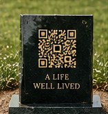Granite marker with a gold QR code reading A life well lived